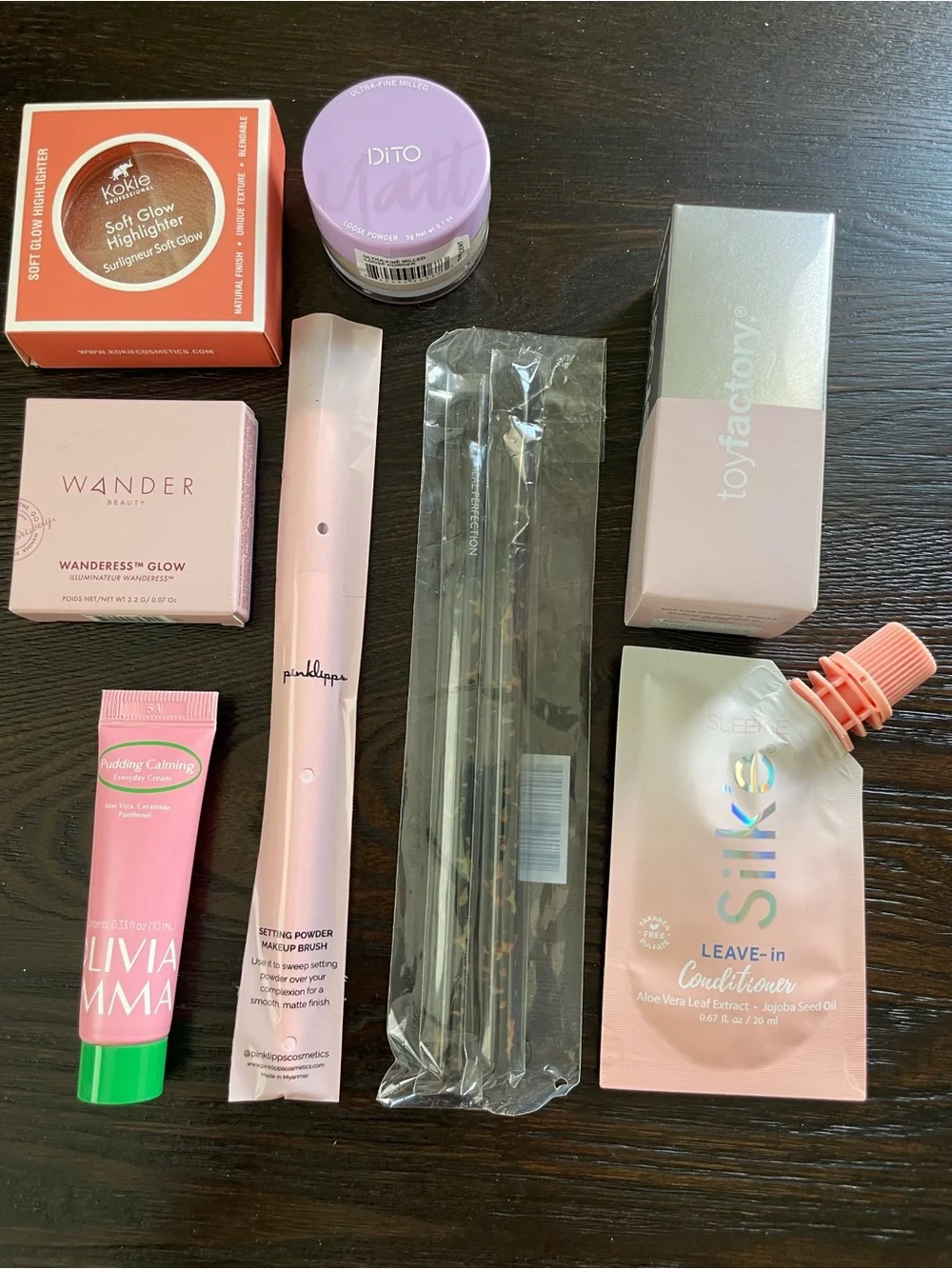 ipsy Pink Tie-Dye and Croc Texture Makeup Pouches with a variety of makeup